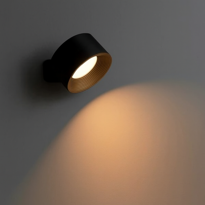 Black spotlight on a gray wall with warm light